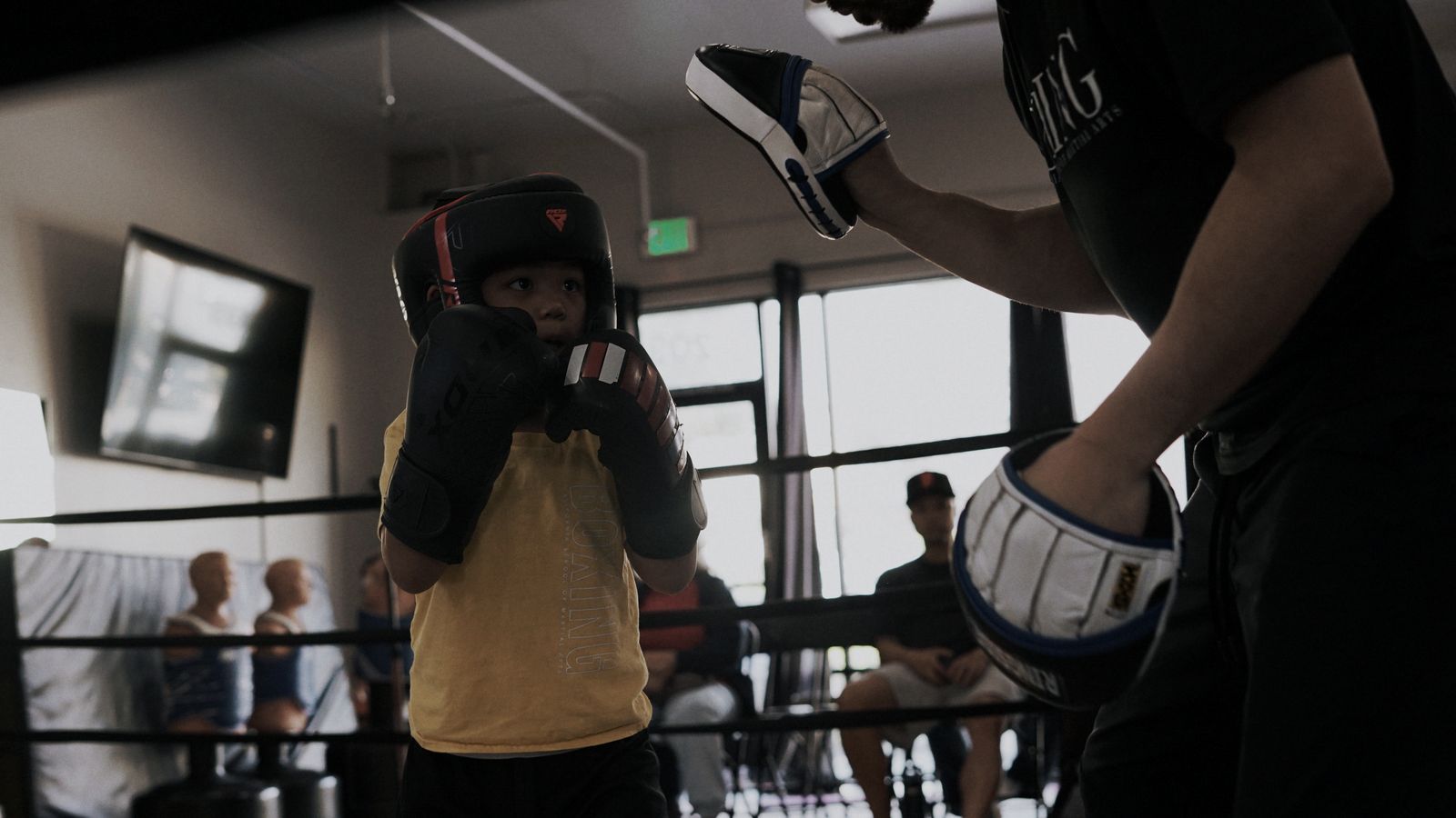 A young boxer working the coach&rsquo;s mitts