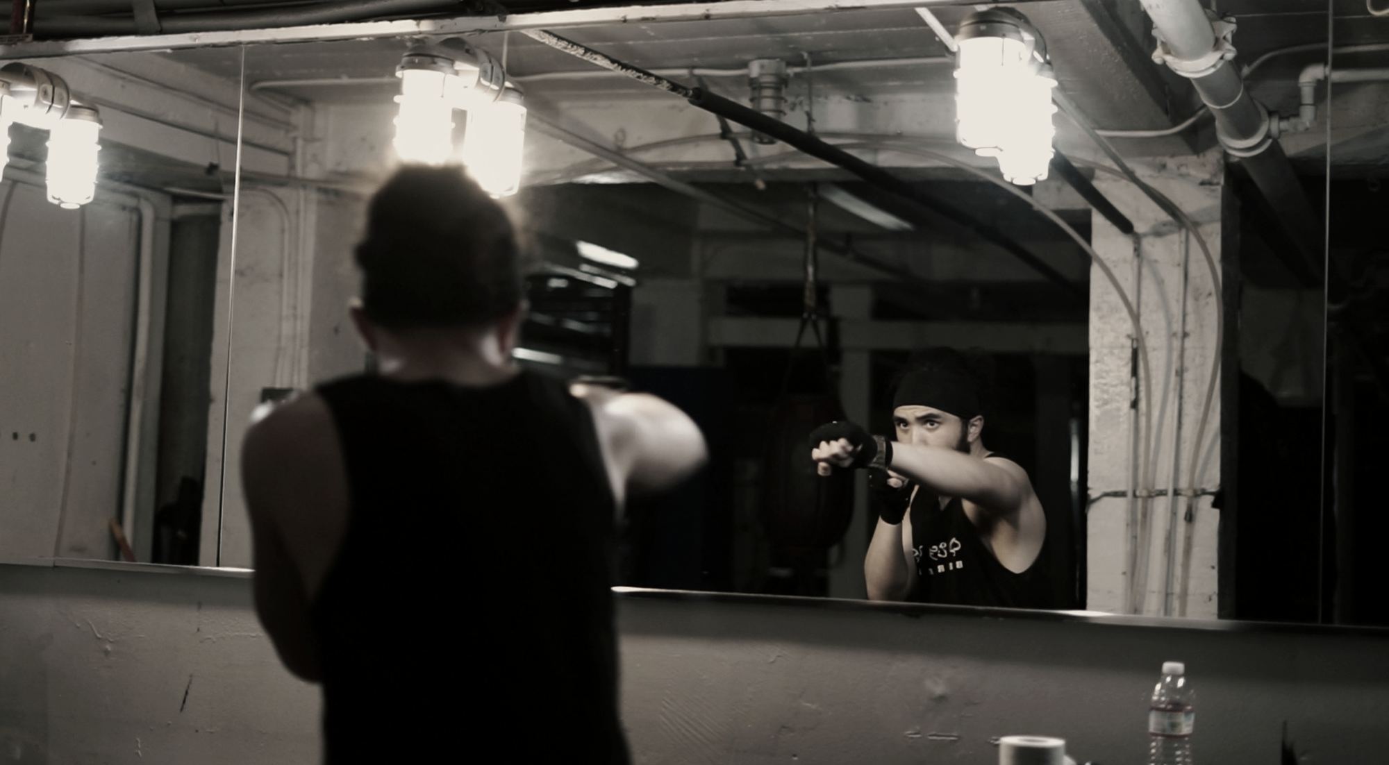 A boxer shadowboxing in front of the gym mirror