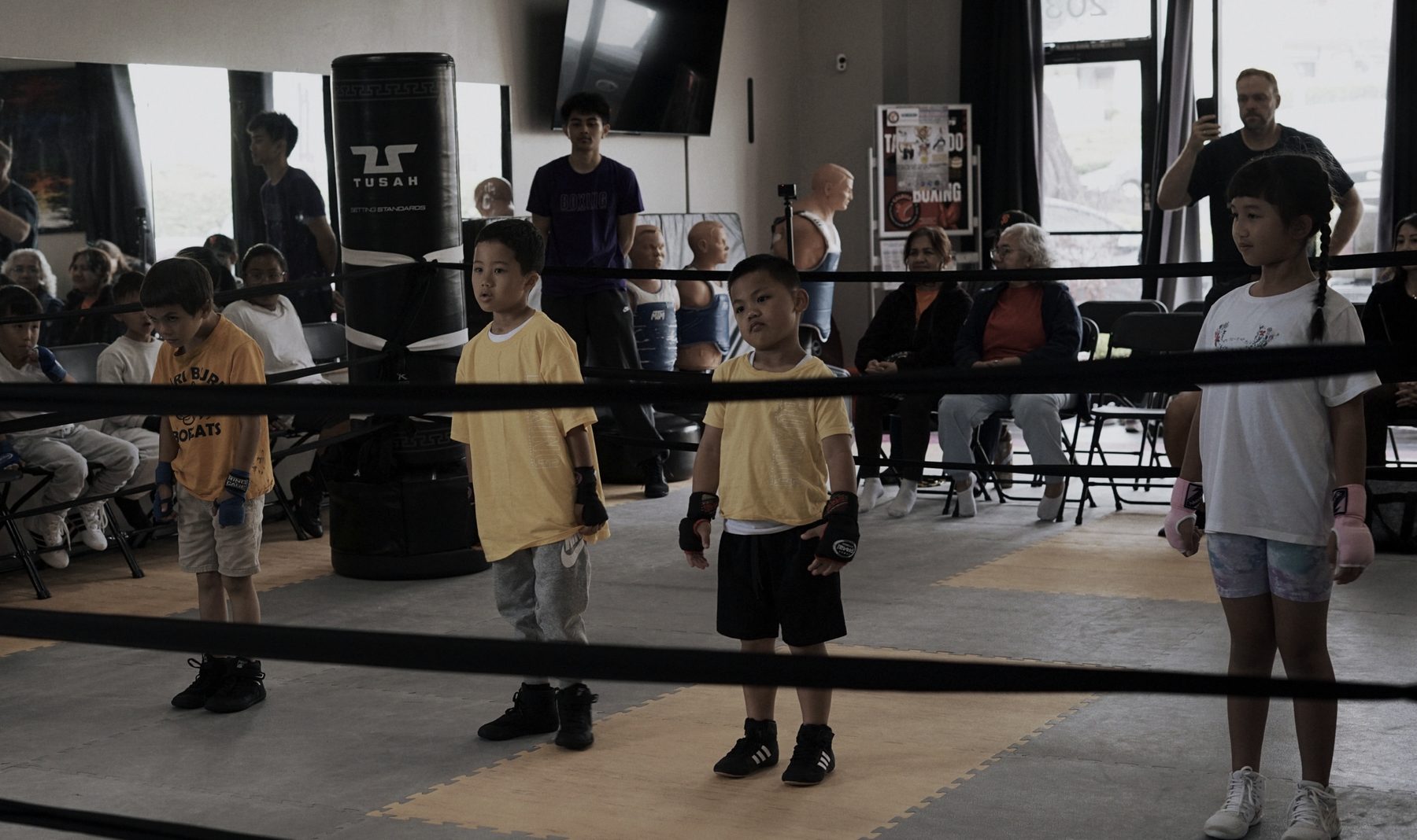 Young boxers lined up in the ring for a rank evaluation